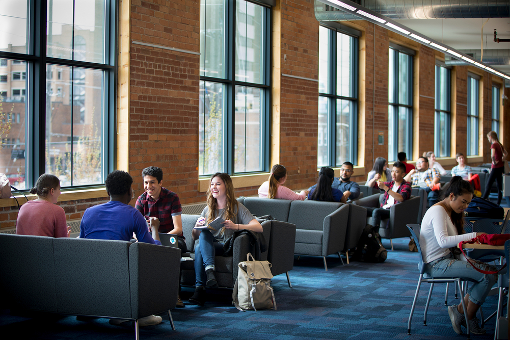 students sitting and talking on couches in 61charles campus.