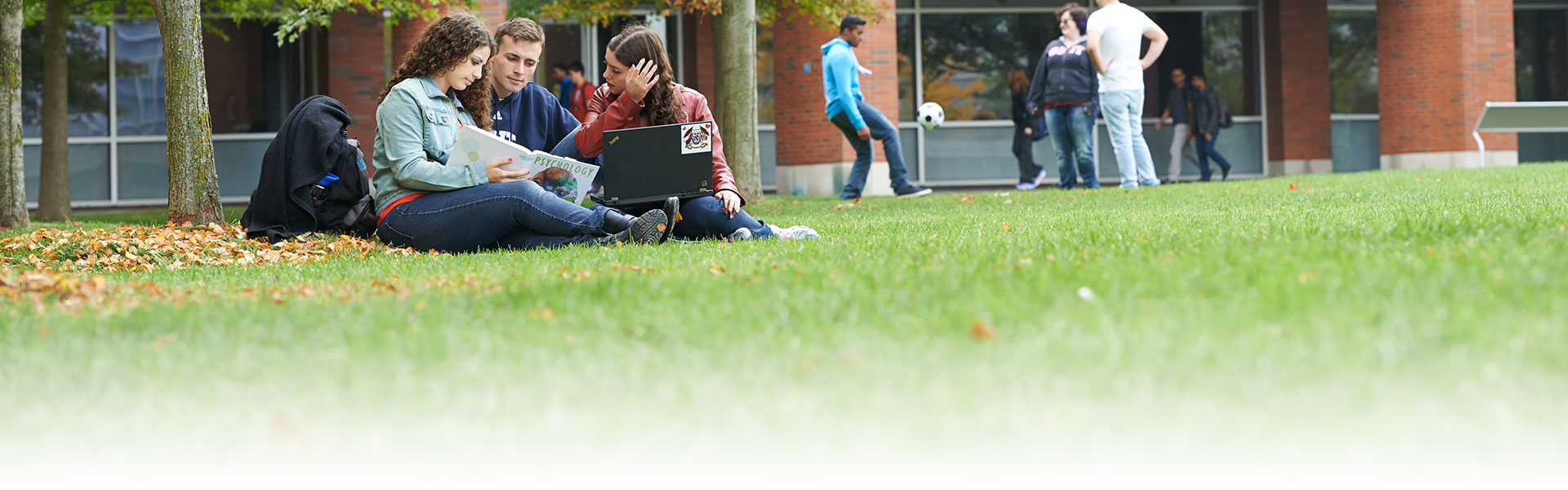 Students sitting outside UOIT building.